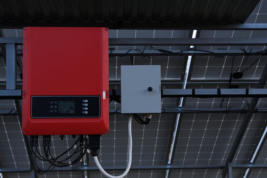 A string inverter and isolator mounted beneath a solar array